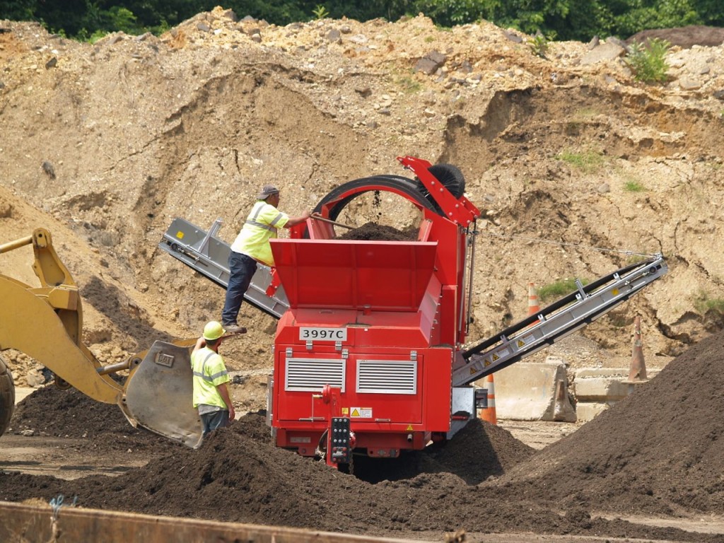 As is often the case, fixing a piece of equipment involves a guy standing on the bucket of a front loader using a pole to move things.