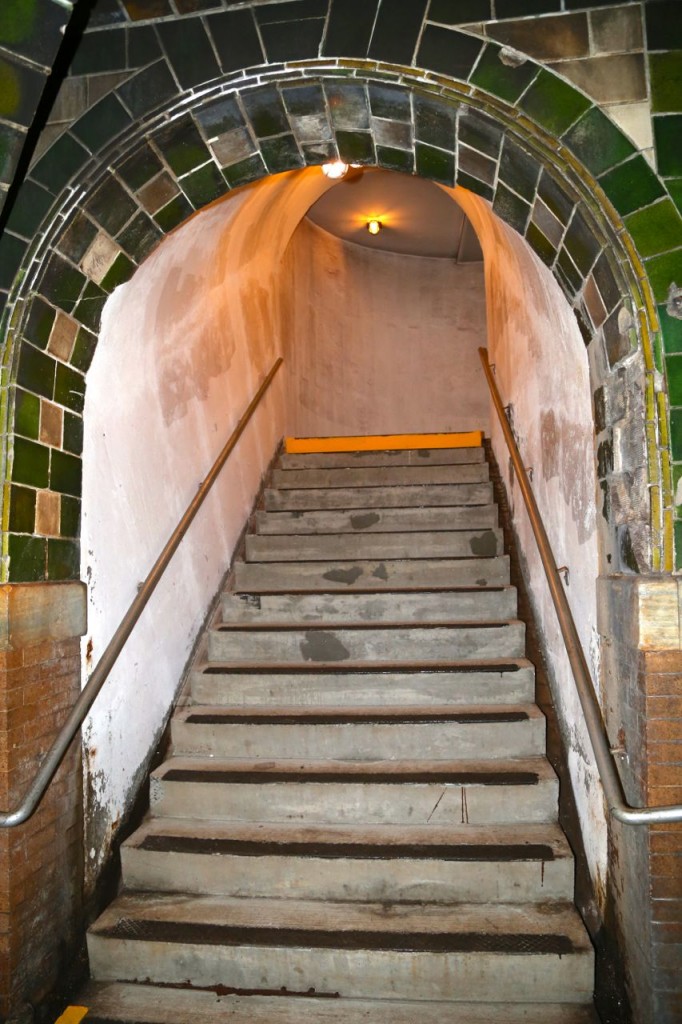 Stairs from mezzanine to surface. Doors now close off the exit.