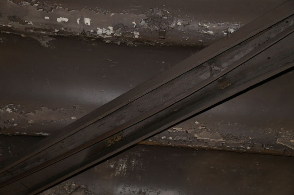Old rail, which is held inside a wooden casing. Wood was used since it doesn't conduct electricity, and rail was electrified.