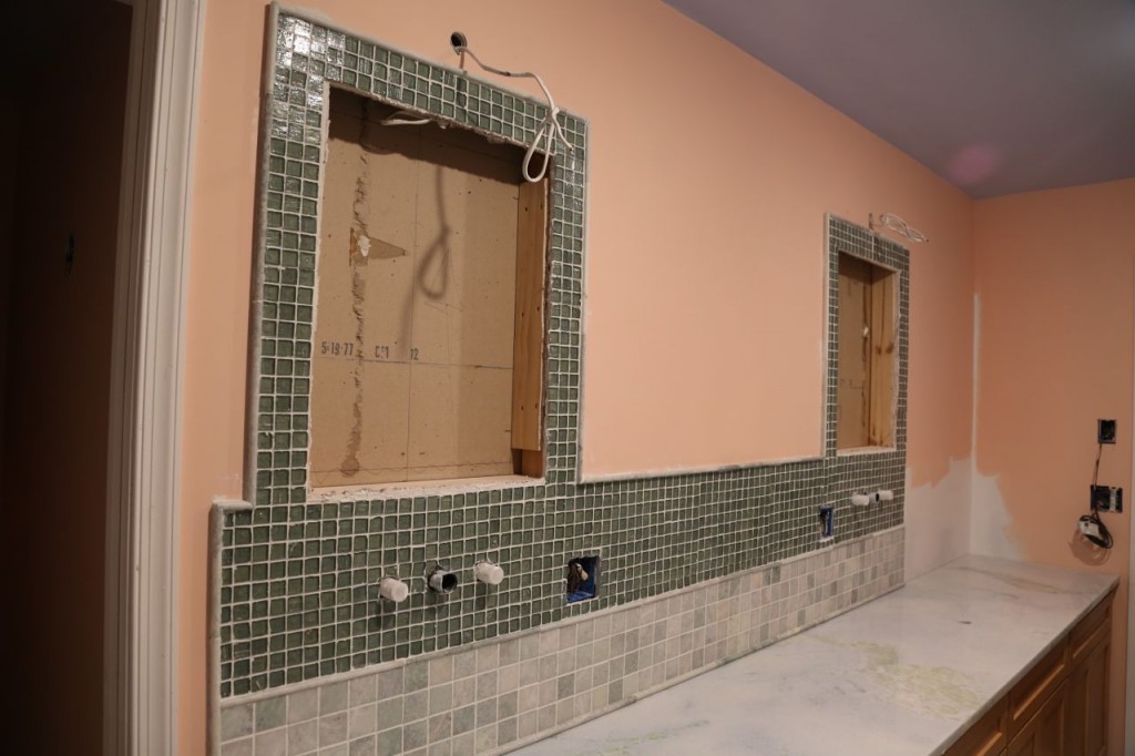 Tiled vanity. Tiling stops before corner where shelving unit will be.