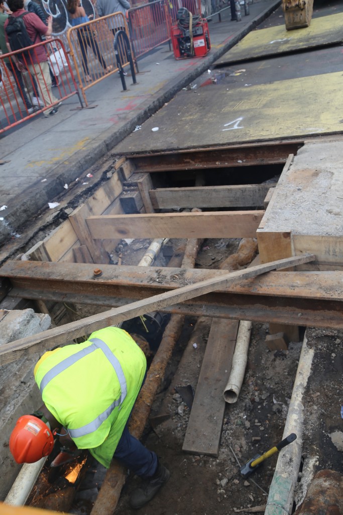 Worker cutting another part of the pipe in a very cramped area