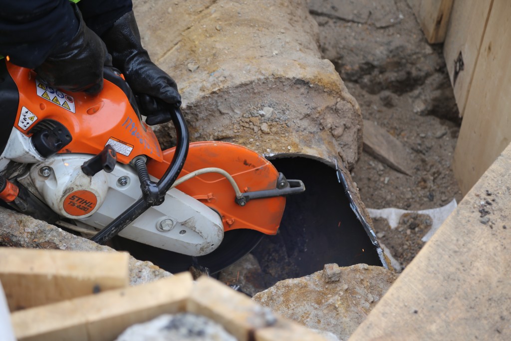 Worker cutting the large previously decommissioned gas pipe