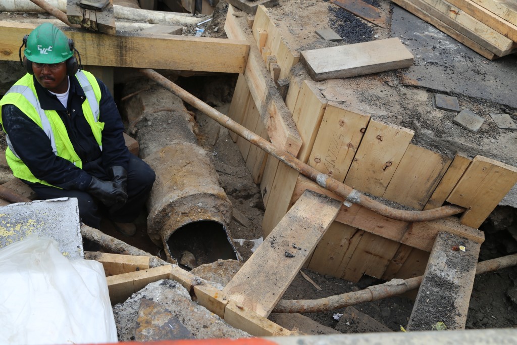 Vertical shoring on the cut sides; the pipe the worker was cutting a hole is in foreground