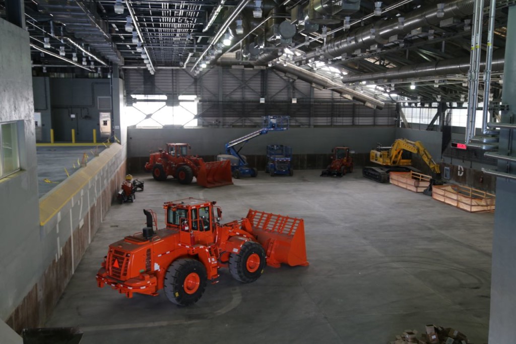 Waste mixing floor with equipment to push waste into containers