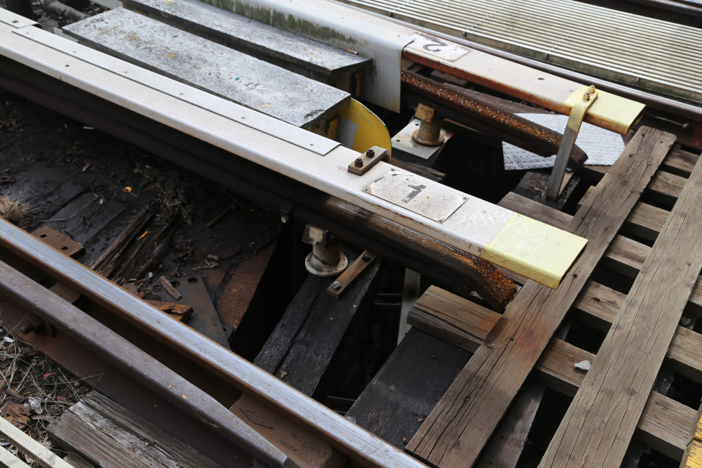 Unclose view of the 3rd rail that ends at the entrance to the shop.