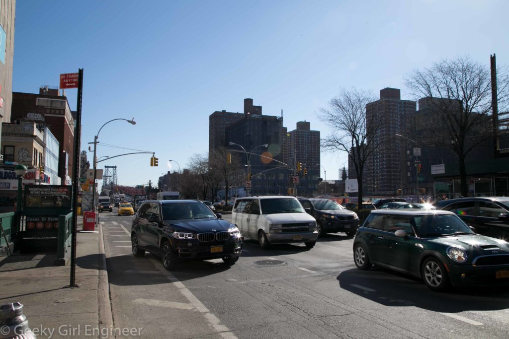 Delancey Street with Williamsburg Bridge in background. Essex Street subway station entrance can be seen on left. Abandoned trolley terminal is right below street.