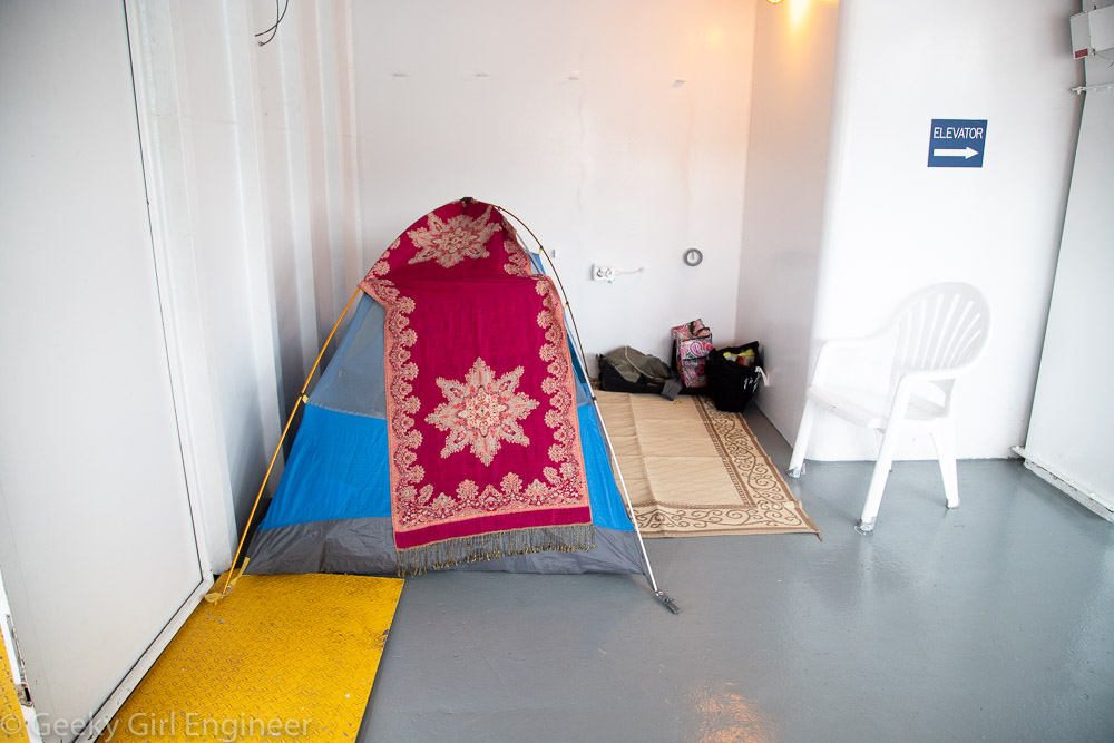 A camping tent with rugs outside it