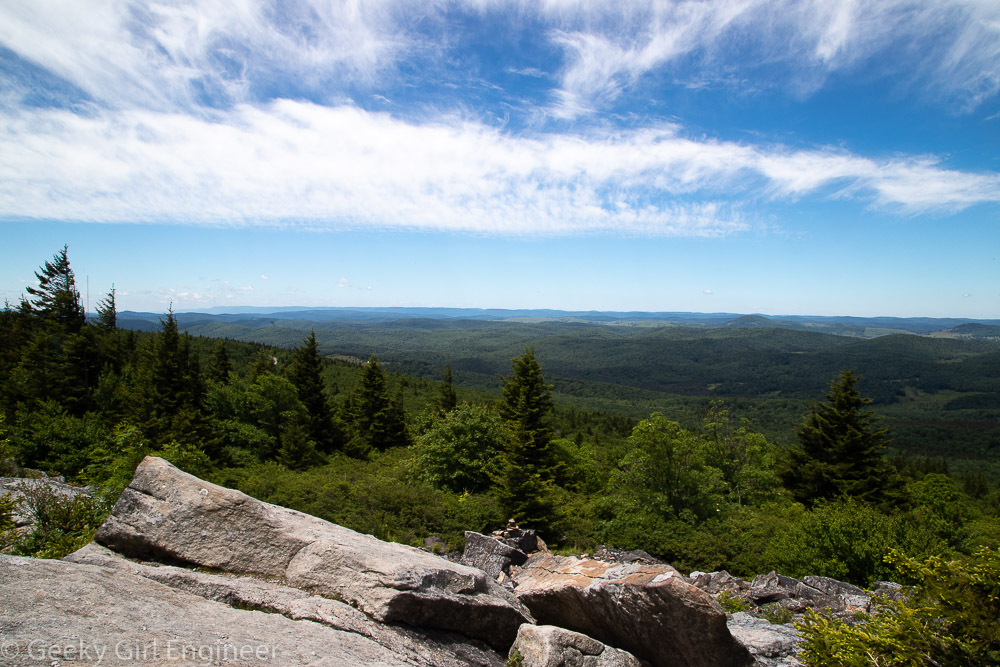 Green tree covered mountains and a blue sky