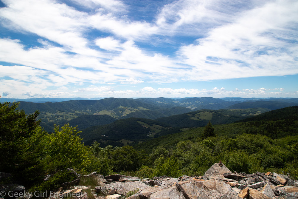 Green tree covered mountains and a blue sky